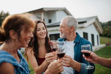 Family toasting with wine during spring family barbecue.