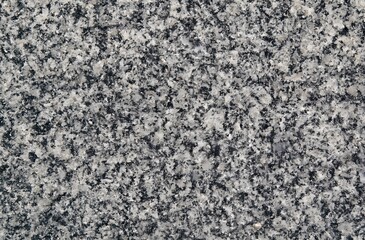 A natural granite stone texture background with a coarse, speckled surface. Mixed tones of gray, white, and black create a rugged and earthy appearance. Ideal for natural design themes
