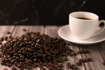 Morning coffee. Roasted coffee beans on a dark background. Cup of coffee