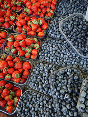 Berries for sale on farmers market. Transparent plastic trays with fresh colorful bilberries or...