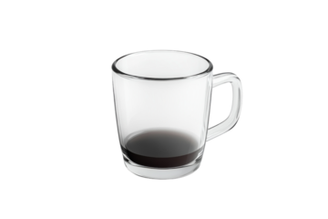 A nearly empty glass mug of dark coffee rests on a white surface in soft light
