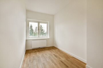 A minimalistic empty room featuring a large window that allows natural light to illuminate the...