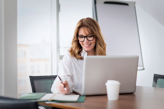 Shot of a blond businesswoman working on a laptop in an office