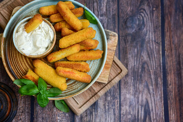  Mozzarella sticks .Italian cheese breaded  oven baked with  fresh basil on wooden background.Italian street food.