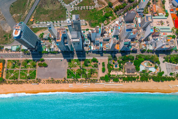 Overlooking panoramic aerial top view city district on the coast vacation beach park palm trees and umbrellas with sun loungers of Southeast Asia in the evening at dawn sunrise Nha Trang