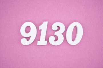 The numbers are made of white painted wood and placed on a pink paper background.