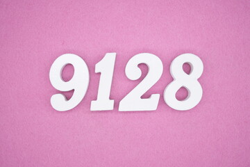 The numbers are made of white painted wood and placed on a pink paper background.