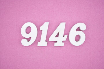 The numbers are made of white painted wood and placed on a pink paper background.