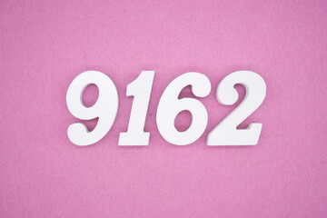 The numbers are made of white painted wood and placed on a pink paper background.
