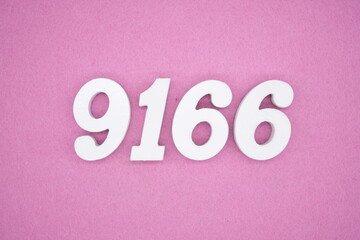The numbers are made of white painted wood and placed on a pink paper background.