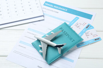 Medical tourism. Travel insurance application form, plane model, passport and flight tickets on...