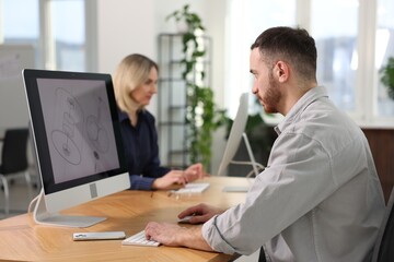 Obraz premium Engineer and his colleague working with computers at table in office