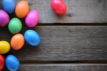 The Easter colorful eggs are lying on the wooden table. The Easter colorful eggs are lying on the wooden table. 