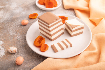 Cocoa and milk jelly with dried apricots on brown concrete background, side view, close up