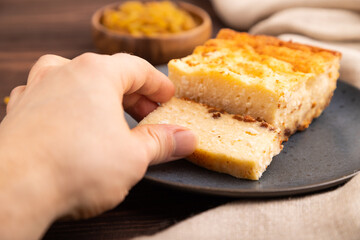 Сottage cheese Сasserole, Curd cake, with dried apricots and raisins with hand on brown wooden, side view, selective focus