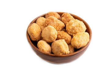 Fried crispy Chicken Nuggets in brown wooden bowl isolated on white. side view