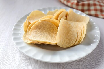 Potato chips in white plate on white background