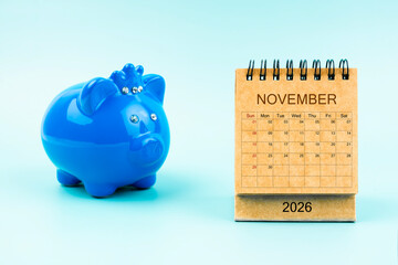 Blue piggy bank and blank November 2026 calendar, Reminder schedule of savings money.