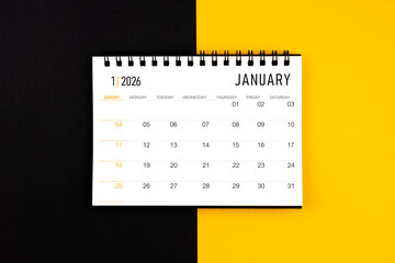 January 2026 desk calendar on black and yellow background, Flat lay.