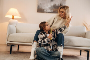 Singing, enjoying free time. Mother and daughter are together in domestic room