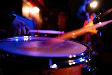 Naklejka premium Drummer performing on stage during a lively music event at night