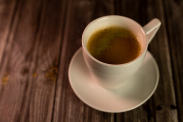 A cup of strong aromatic coffee on a dark background. Coffee in a white cup
