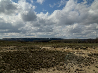 Field with a cloudy sky in the background. The sky is mostly cloudy with some patches of blue