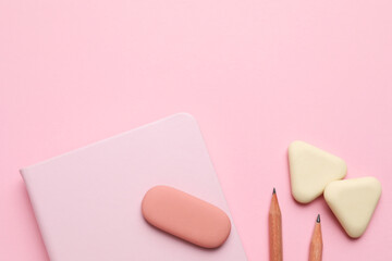 Erasers, notebook and pencils on pink background, flat lay