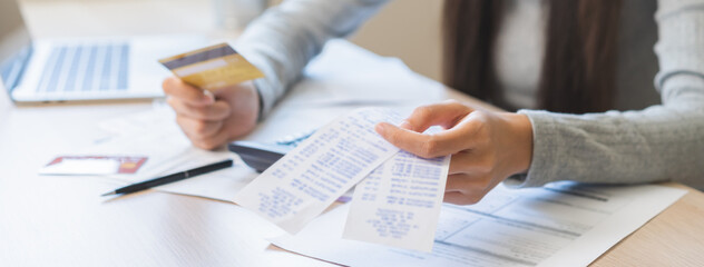 Business financial concept, stressed asian young business woman hand holding credit card for calculate accounting expense of bill, tax for payment on due deadline, trying to find money to pay debt.