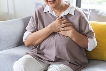 Chest pain, attack chest, emergency heartbeat asian senior woman holding hand on chest, suffering...