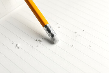 Using pencil with eraser on white sheet of paper, closeup