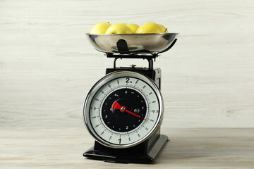Retro mechanical kitchen scale with apples on wooden table
