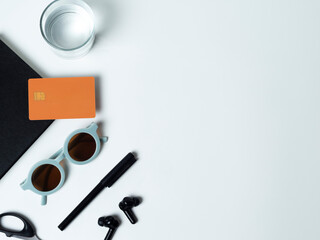 Office desk with top view of white credit card on black book and black pen on white background. Online payment business concept.