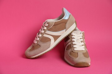 Pair of stylish sneakers on pink background. Casual shoes