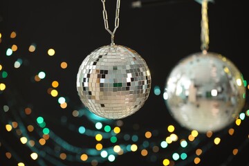 Shiny disco ball on black background with blurred lights