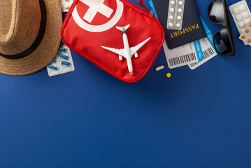 Flat lay of travel accessories including a hat, first aid kit, plane, and medical supplies indicating safety and preparedness during travel