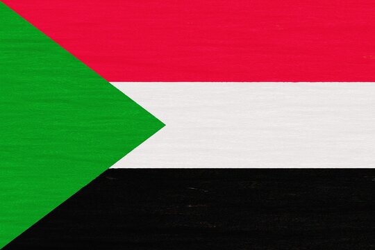 Wooden texture painted in colors of flag of Sudan. Flat view