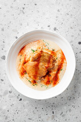 A succulent piece of chicken served in a creamy sauce, garnished with paprika and fresh herbs. This dish combines rich flavors and textures, making it perfect for any gourmet meal.