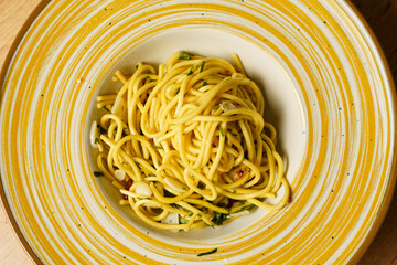 Close-up of plated spaghetti aglio e olio on a wooden table