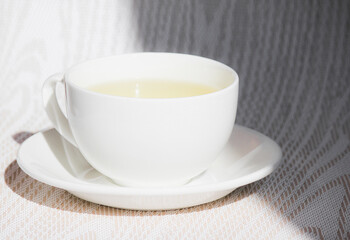White cup and saucer with mint tea