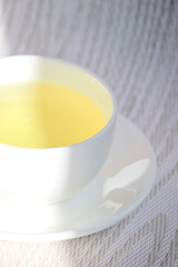 White cup and saucer with mint tea