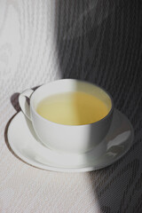 White cup and saucer with mint tea