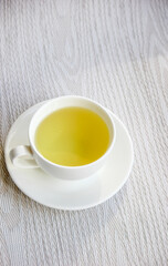 White cup and saucer with mint tea