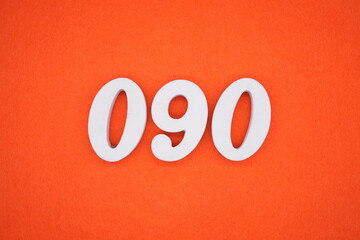 The numbers are made of white painted wood placed on an orange paper background.
