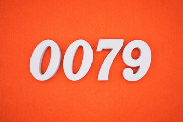 The numbers are made of white painted wood placed on an orange paper background.