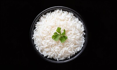 Bowl of fluffy white rice garnished with fresh cilantro on a contrasting black background