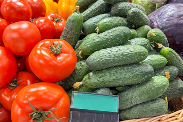 Fresh cucumbers and vibrant tomatoes are displayed together in a grocery store produce section