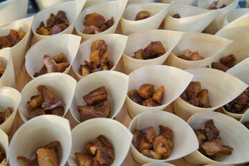 paper cone with pieces of meat to serve in the catering of a celebration.
