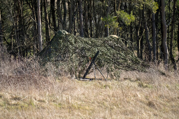 army camouflage netting cover deployed to hide broadcast equipment