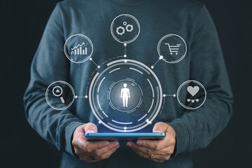 A man holds a tablet with a virtual hologram of digital marketing icons and a human icon inside it, a business concept for customer profile management or social media targeting and basic data analysis